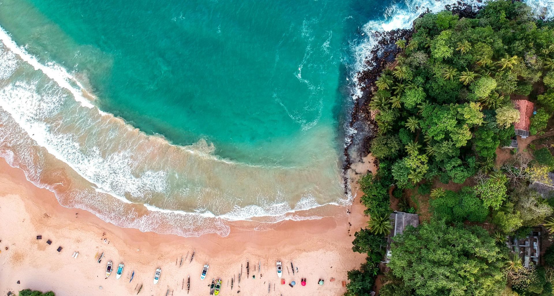 A drone view of lovely beach with turquoise water and a few boats